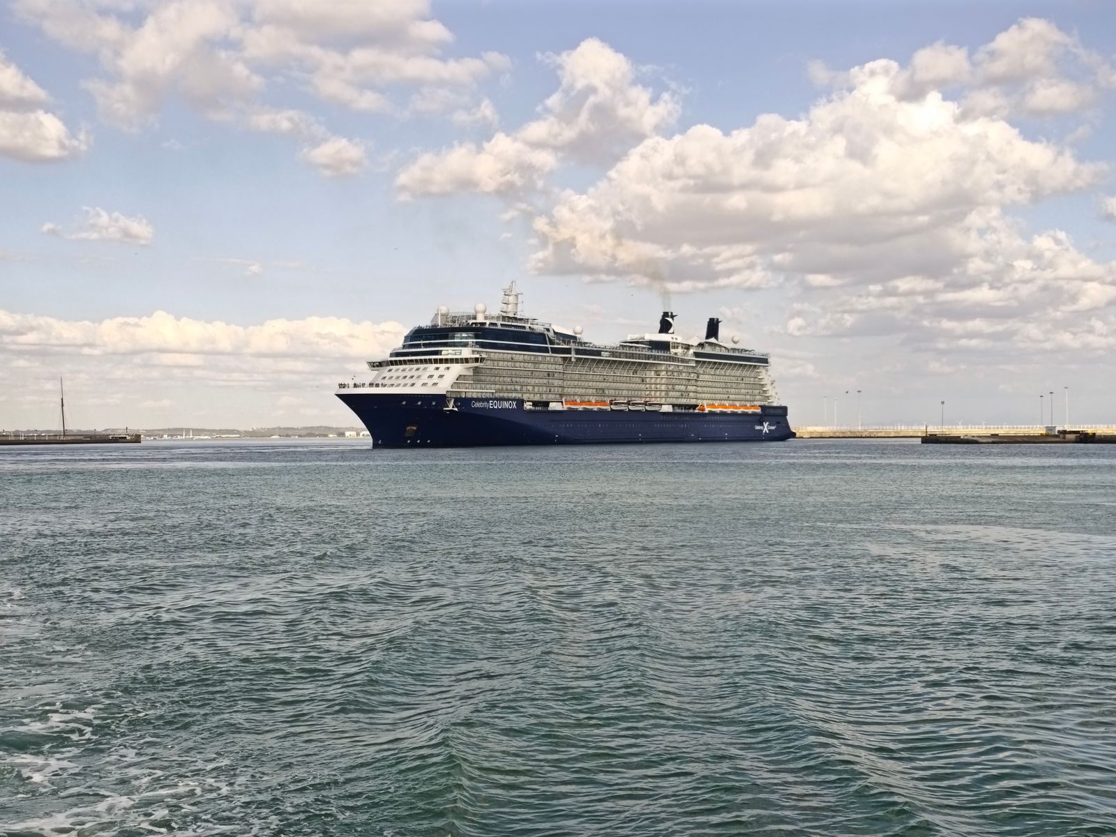 Large cruise ship leaving harbor under a cloudy sky, the product a master cruise consultant sells